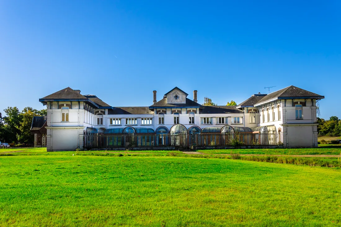 Façade Belle Époque du bâtiment hôtel-restaurant du Domaine, entourée de pelouses
